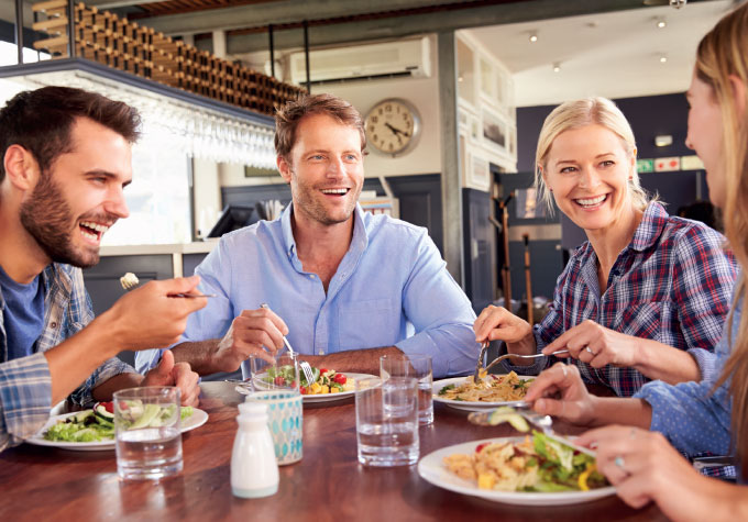 A group of young friends enjoying a meal at a table