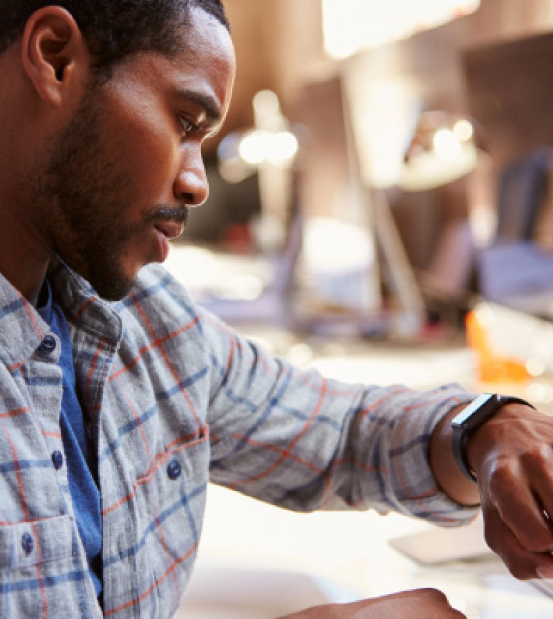 A black male checking time on his wristwatch